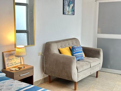 a gray chair with two pillows on it in a bedroom at Margarita's room in Morales