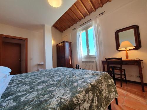 1 dormitorio con cama, mesa y espejo en Residence Le Meridiane, en Siena