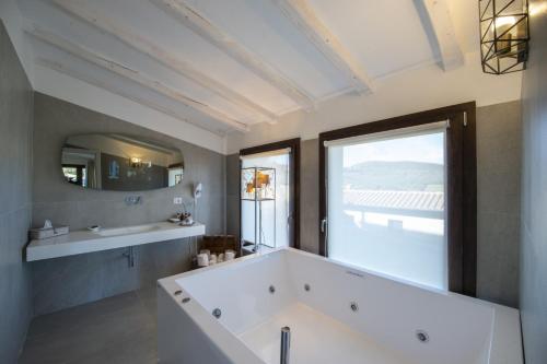 a bathroom with a large tub and a large window at Villa il Giardino - Homelike Villas in Greve in Chianti