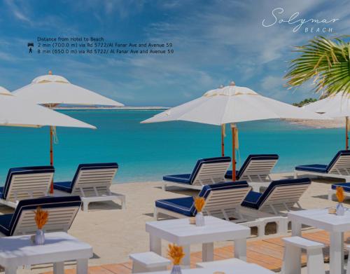 een strand met stoelen en parasols en de oceaan bij The Grove Hotel & Conference Centre Bahrain in Manamah
