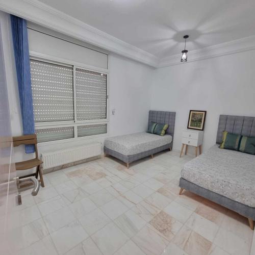 a living room with two beds and a couch at City View, Ennasr Spacious s2 Apartment in Ariana