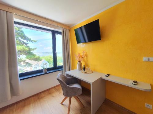 a yellow room with a desk and a window at Sousedi Pavlov in Pavlov