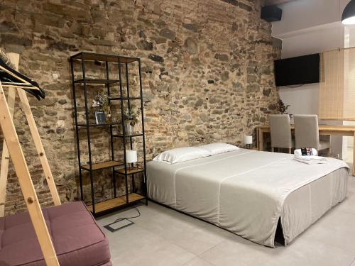 a bedroom with a bed and a brick wall at Luxury Apartment Stancesvic LOFT (New) in Vic
