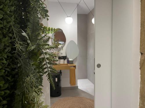 a bathroom with white walls and a large green plant at Luxury Apartment Stancesvic LOFT (New) in Vic