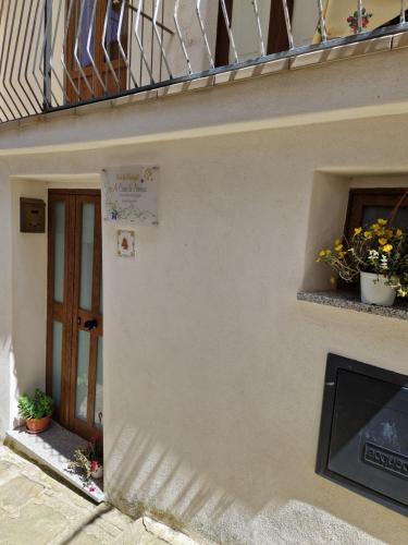a building with a balcony and a door and plants at A Casa di Nonna in Castelsaraceno