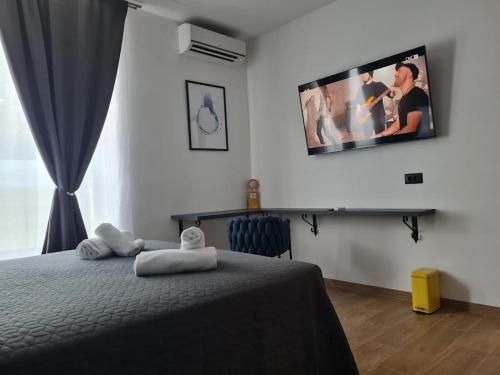 1 dormitorio con 1 cama y TV en la pared en Lux Room 303, en Zadar