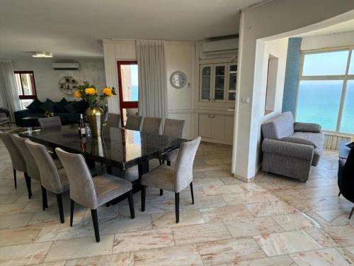 a dining room with a black table and chairs at Sea-front apartment Netanya in Netanya