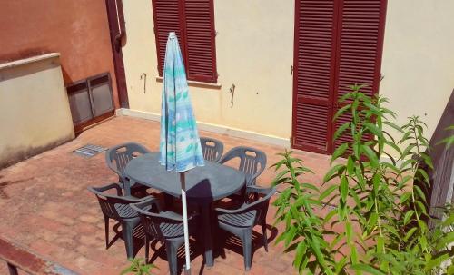 a table with chairs and an umbrella on a patio at Residence Le Meridiane in Siena