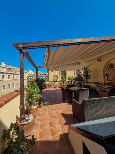 un patio con mesas y sillas en la azotea en Upper Garden Guest House, en Cagliari