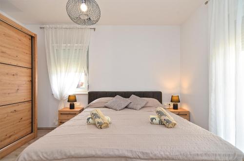 a bedroom with a large bed with two pillows on it at House Tea 2279 in Medulin