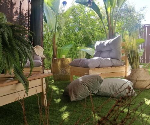 a patio with two benches with pillows and plants at B&B DOMUS 65 in Aragona