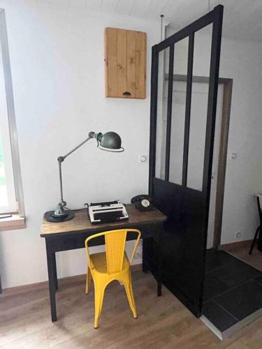 un bureau avec une lampe et une chaise jaune dans l'établissement Le Refuge de la Gravière, à Charleville-Mézières