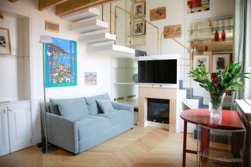 a living room with a blue couch and a fireplace at L'échelle Rouge in Cannes