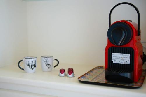 a red toaster and three coffee cups on a counter at L'échelle Rouge in Cannes