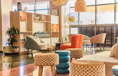 a room with chairs and tables in a room at Leonardo Hotel Fuengirola Costa del Sol in Fuengirola