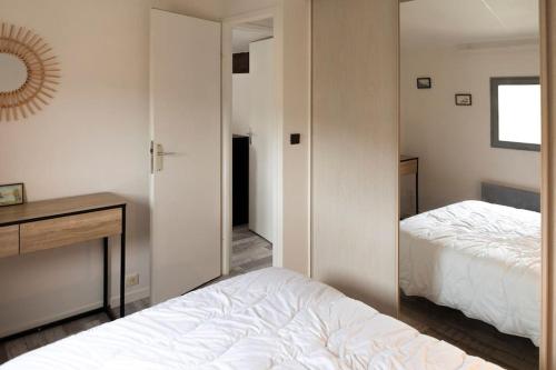 um quarto com uma cama, uma secretária e um espelho em Apparement T3 avec vue mer em Roquebrune-sur-Argens