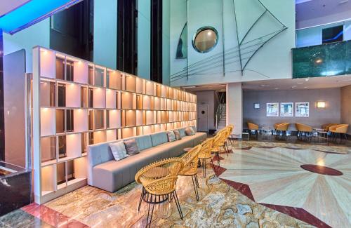 a lobby with a couch and tables and chairs at Leonardo Hotel Fuengirola Costa del Sol in Fuengirola