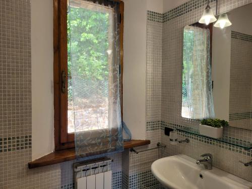 ein Bad mit einem Waschbecken und einem Fenster in der Unterkunft Villa Il Fontanino in Monticiano