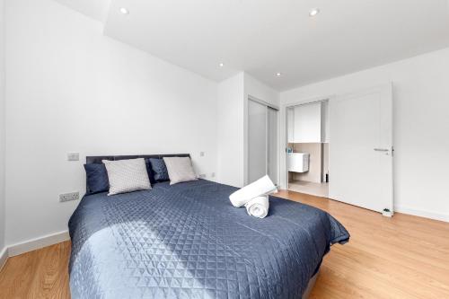 Schlafzimmer mit einem großen Bett mit blauer Decke in der Unterkunft London's Charm 2 BR Flat CB3 in Croydon