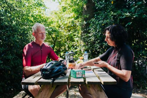 Ein Mann und eine Frau sitzen an einem Picknicktisch in der Unterkunft Trekkershut I Ideale uitvalsbasis op de Veluwe in Epe