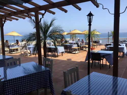 a beach area with tables, chairs and umbrellas at Manolya Hotel in Kyrenia