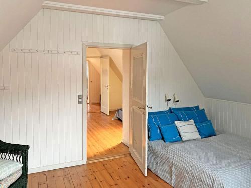 a bedroom with a bed with blue pillows at Holiday home Svaneke LVI in Svaneke