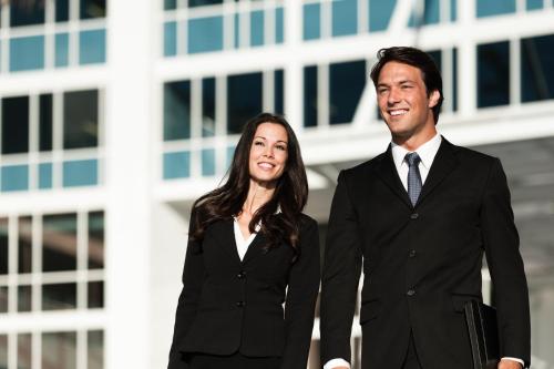 a man and woman in suits standing in front of a building at Penthouse with Balcony in Luton