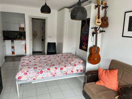 Un dormitorio con una cama y una guitarra en la pared en Istamboul Heist beach, en Knokke-Heist