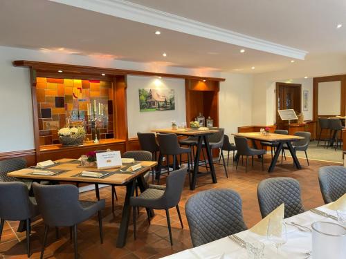 - un restaurant avec des tables et des chaises dans une salle dans l'établissement Landhotel Vessens Hoff, à Buchholz in der Nordheide