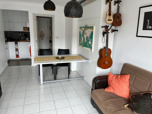 sala de estar con sofá y mesa con guitarra en Istamboul Heist beach, en Knokke-Heist