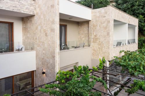 an external view of a building with plants at Apart-Hotel President in Ulcinj