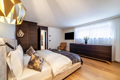 a bedroom with a large bed and a large window at Schenna Chalet - Apt Dora in Schenna