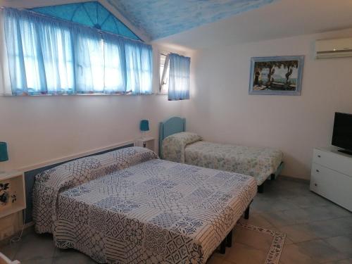 Habitación pequeña con 2 camas y TV. en B&B Al Verde & Mare, en Porto Garibaldi