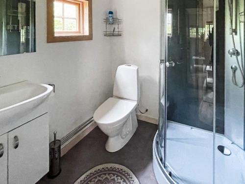 a white bathroom with a toilet and a shower at Holiday home Drottningskär in Drottningskär