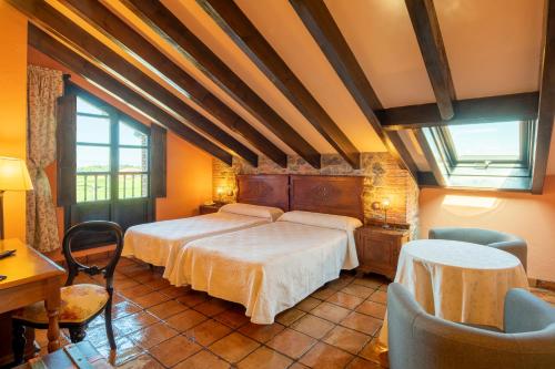 1 dormitorio con 1 cama, mesa y sillas en Globales Playa de Las Llanas, en Muros de Nalón