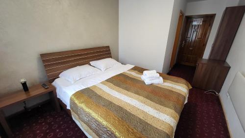 een hotelkamer met een groot bed en een bureau bij Boutique Global in Braşov