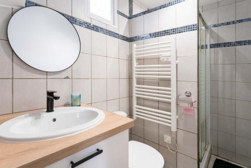 een badkamer met een wastafel en een spiegel bij La maison d'à côté in Carpentras