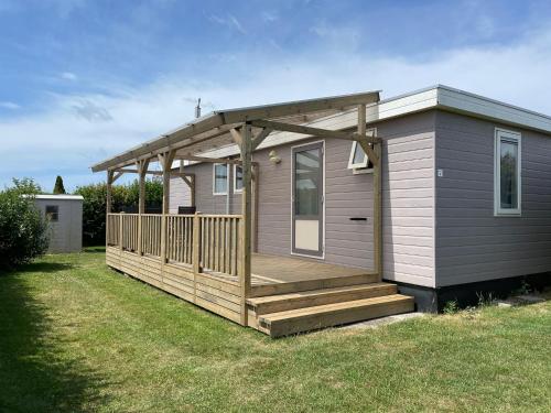 a small house with a porch and a deck at Chalet Boerennest bij strand en duinen - Midicamping Van der Burgh - Rockanje in Rockanje