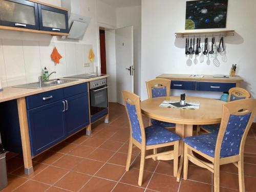 a kitchen with a wooden table and blue cabinets at Oreste in Overath
