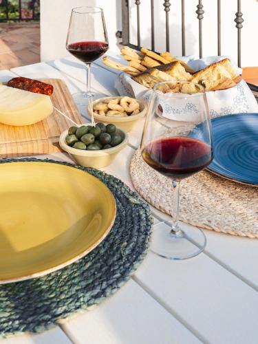 a table with plates and glasses of wine and food at Villa Antonella in Pisticci