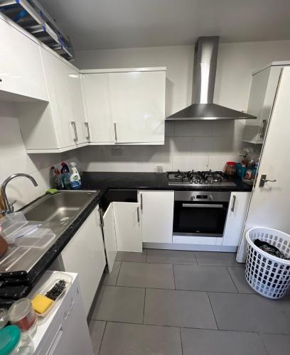 a kitchen with white cabinets and a stove top oven at Sterne Street in London