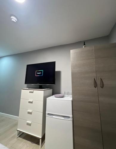 a room with a tv and a dresser with a refrigerator at Sterne Street in London