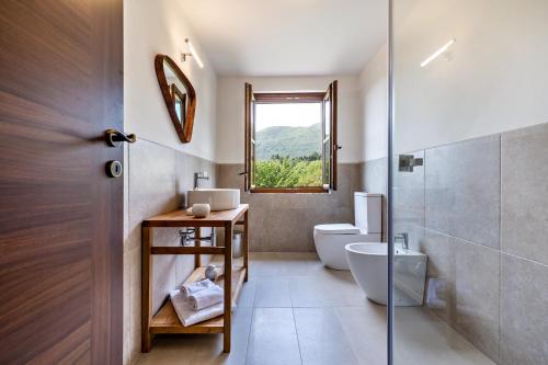 a bathroom with a toilet and a sink and a window at Nonna Gina in Tignale