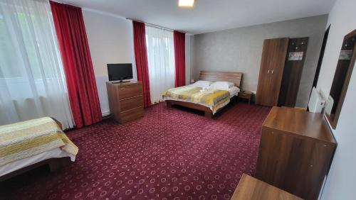 een hotelkamer met twee bedden en een televisie bij Boutique Global in Braşov