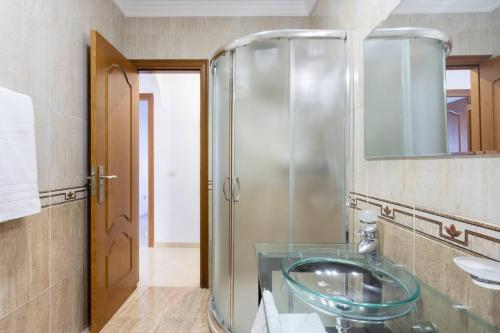 y baño con lavabo de cristal y ducha. en Alojamiento acogedor y tranquilo en La Orotava