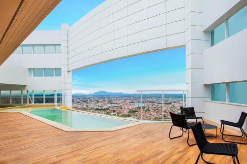 uma vista do telhado de um edifício com cadeiras e uma piscina em NH HOTEL FEIRA DE SANTANA em Feira de Santana