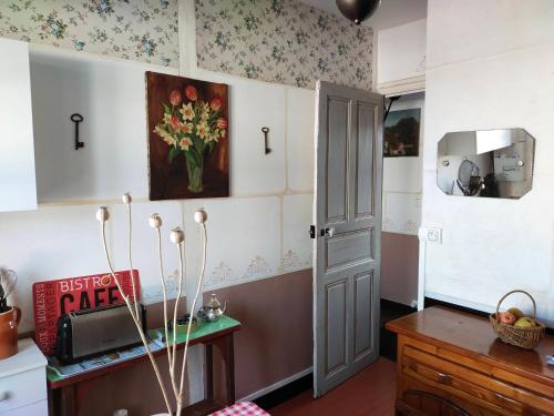 una cocina con un jarrón de flores en la pared en Le Jardin Yuccas - Cosy cottage in the Loir& Loire Valleys, en La Chapelle-aux-Choux