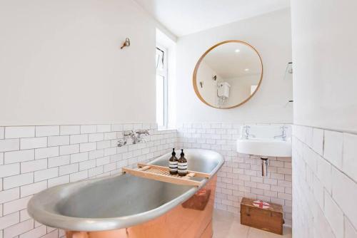 a bathroom with a tub and a sink at Sea Purse - Spectacular house on the beach in Kent
