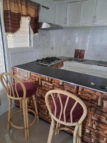 cocina con 2 sillas y encimera en Town Centre Stays en Nadi