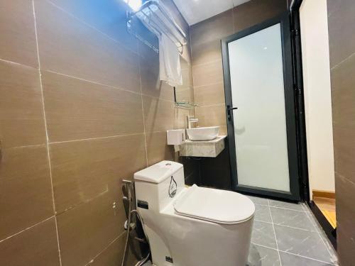 a bathroom with a toilet and a sink at Torino Hotel Dalat in Da Lat